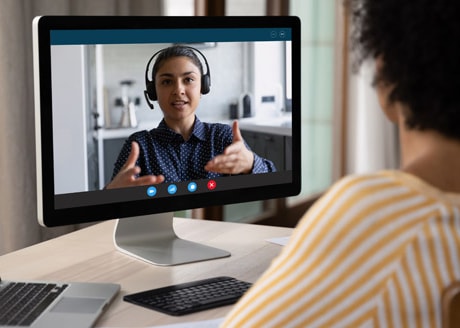 stock photo of a woman in a video call with another woman in professional clothing who is wearing a headset